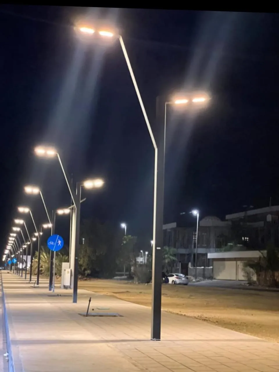 أعمدة إنارة متعددة الأذرع بكشّافات LED في موقف سيارات لمجمّع تجاري من أكتار في المملكة