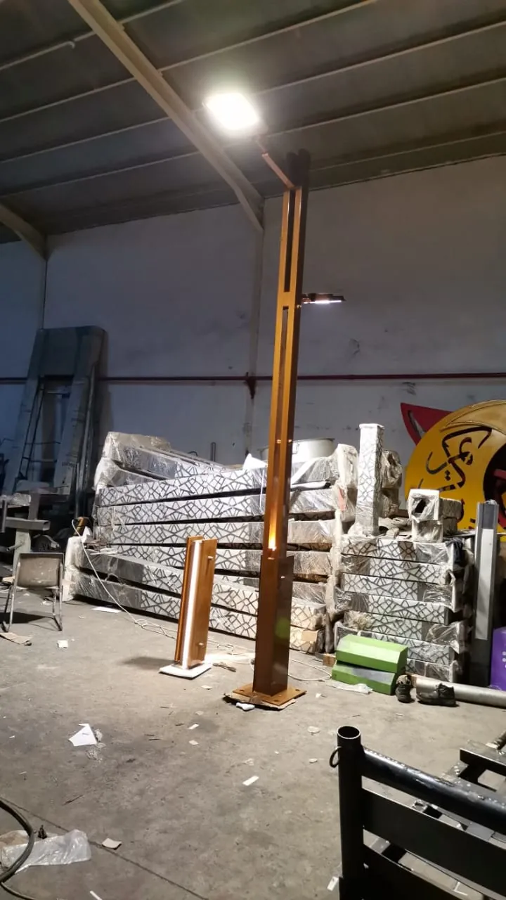 عمود إنارة ديكوري بلون خشبي بإضاءة LED من تنفيذ مصنع أكتار لمشروع منتزه الثورة العربية في الباحة