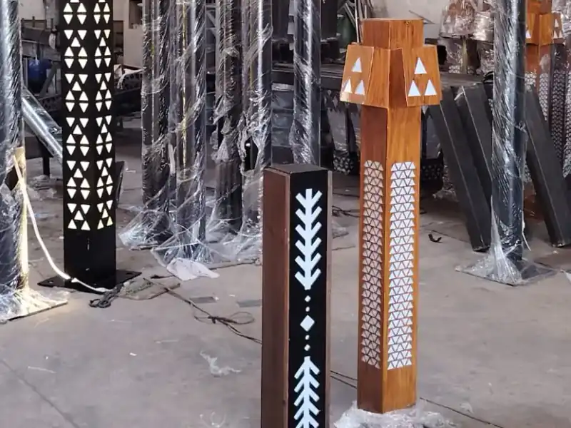 أعمدة إنارة ديكورية بلون خشبي وزخارف مقصوصة بالليزر داخل مصنع أكتار قبل توريدها لمشروع حوطة بني تميم